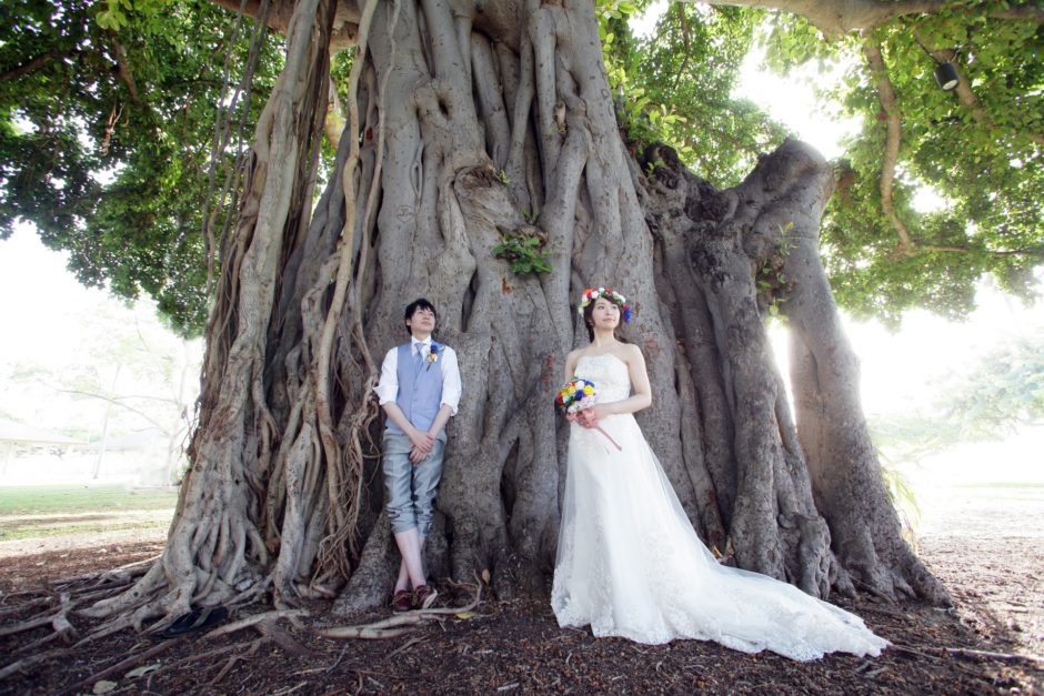 結婚式で木にもたれ掛かる新郎新婦